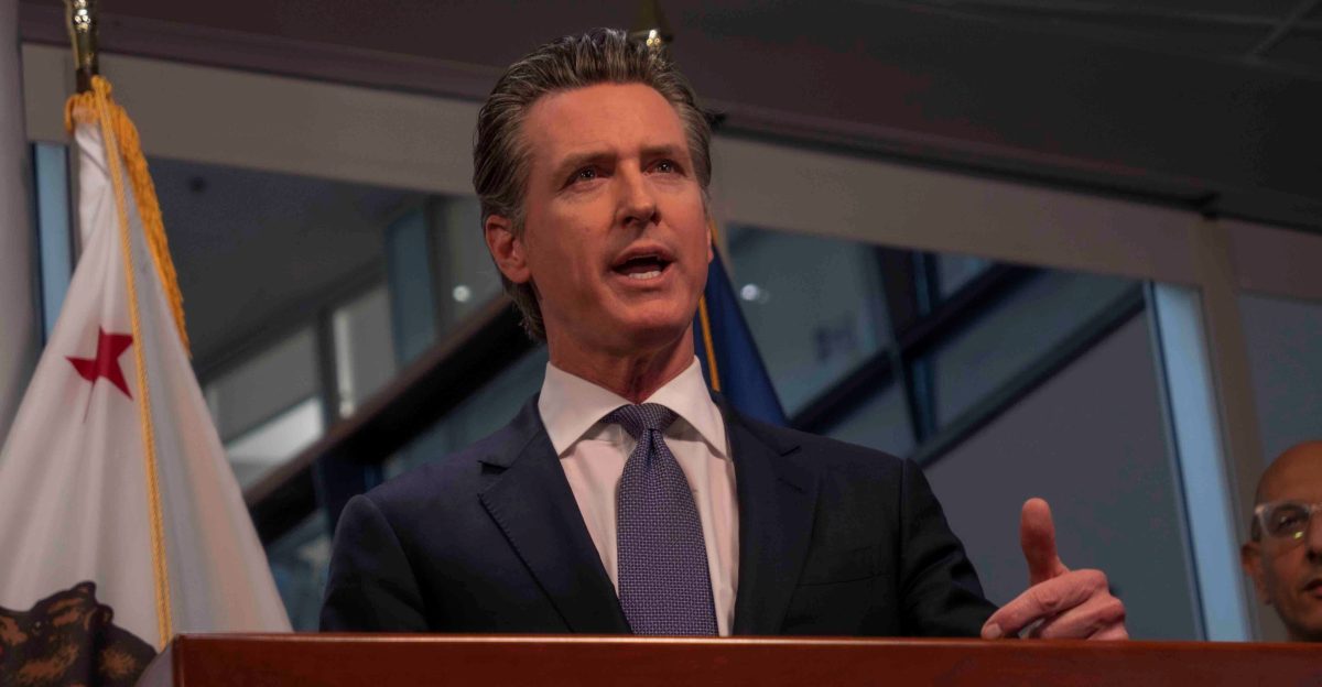 Gavin Newsom speaking at a podium in Sacramento