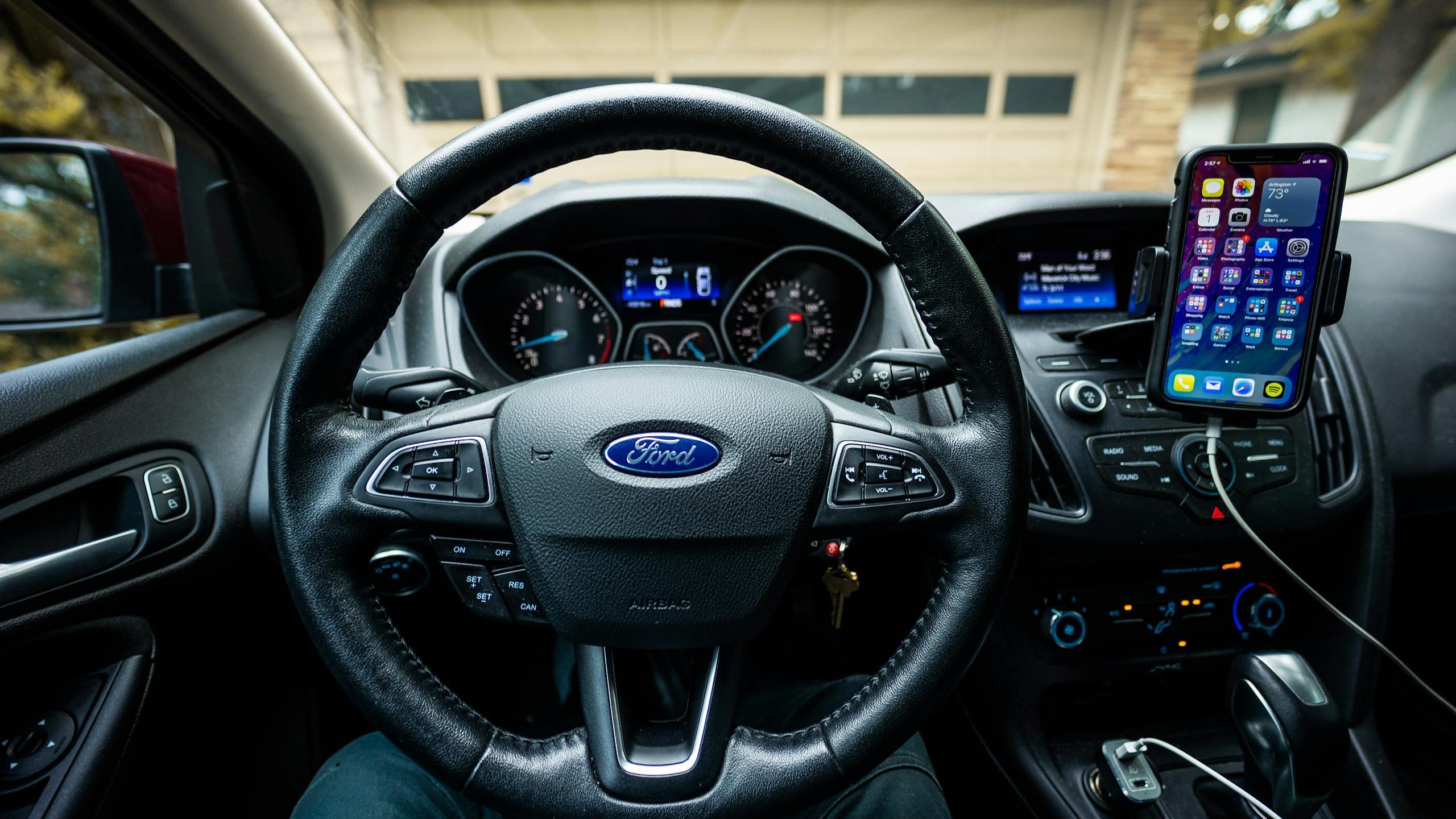 Interior view of a Ford car featuring a steering wheel, dashboard, and mobile device mount.