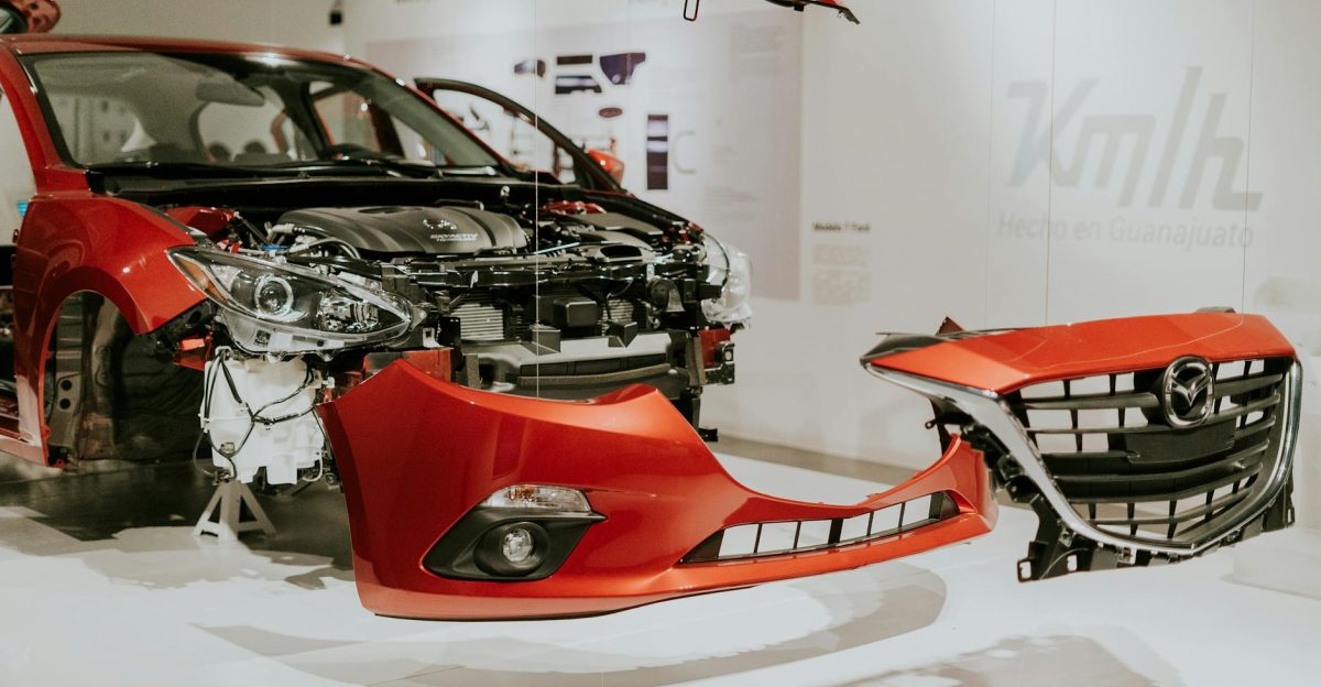 Explore a detailed view of a partially disassembled red Mazda 3 showcased at an auto exhibition