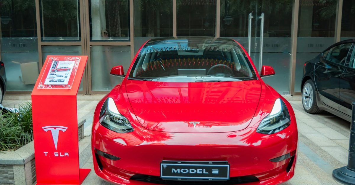 A stylish red Tesla Model 3 parked in an urban area showcasing its sleek design and luxury features