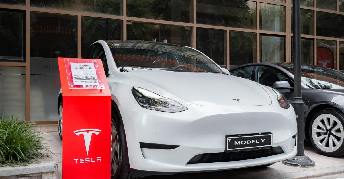 Tesla Model Y parked outdoors with a red display stand in front Modern and sleek automotive design
