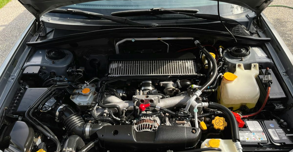 Close-up view of car engine with visible components under the open hood