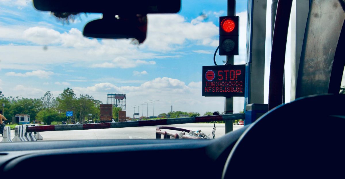 Car interior view at a toll booth in Suryapet India with a stoplight