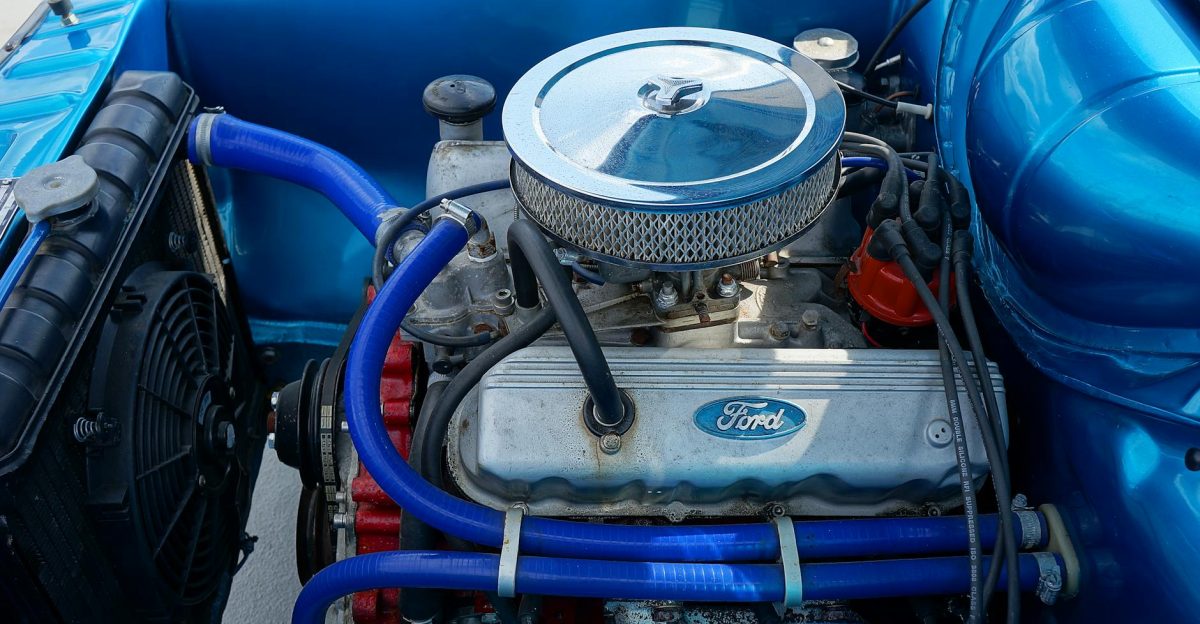 Close-up view of a classic Ford car engine with blue components highlighting mechanical details