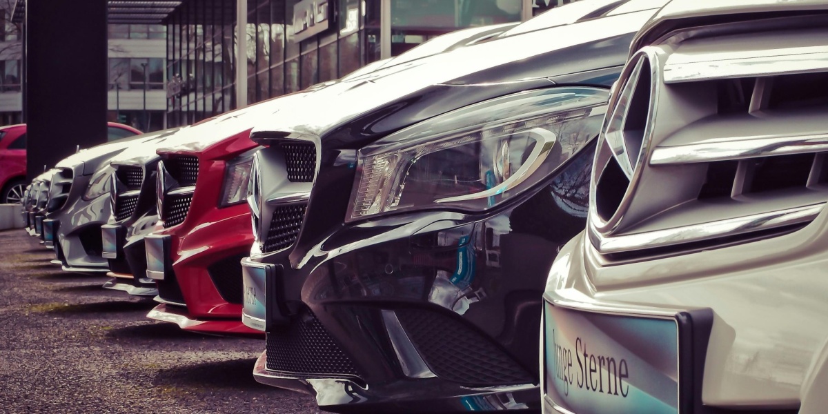 Luxury cars lined up at an outdoor dealership, showcasing sleek designs.