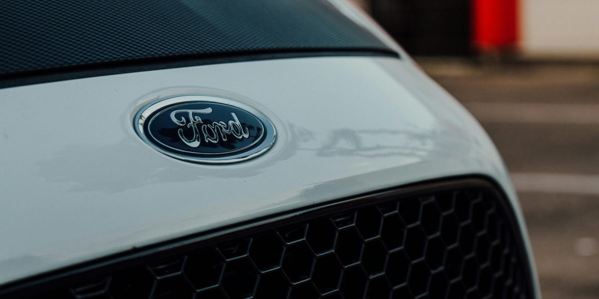 Detailed close-up image showcasing a white Ford car emblem on the vehicle's grille.