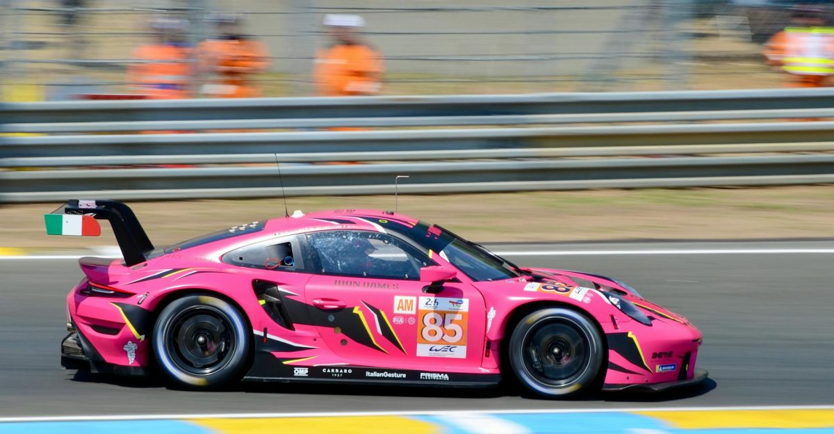 Vibrant pink race car zooming past at Le Mans France during a motorsport race