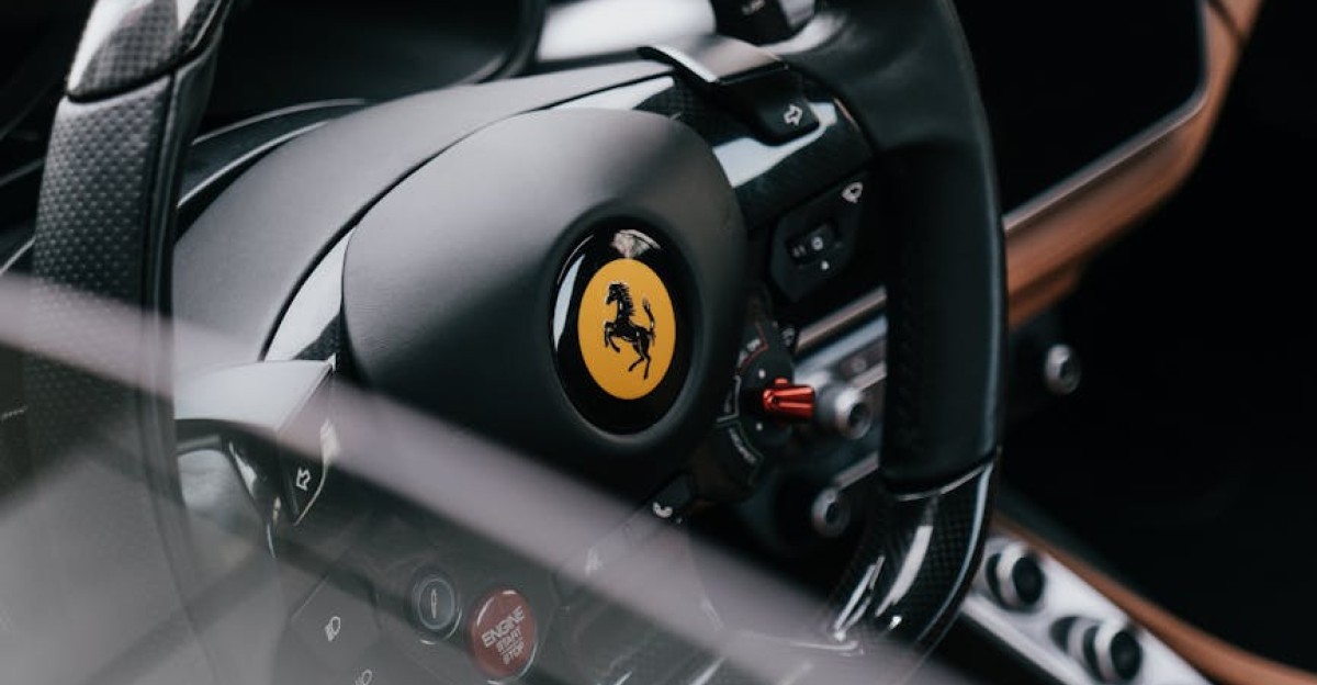 Close-up of a Ferrari sports car steering wheel showcasing luxury design and craftsmanship
