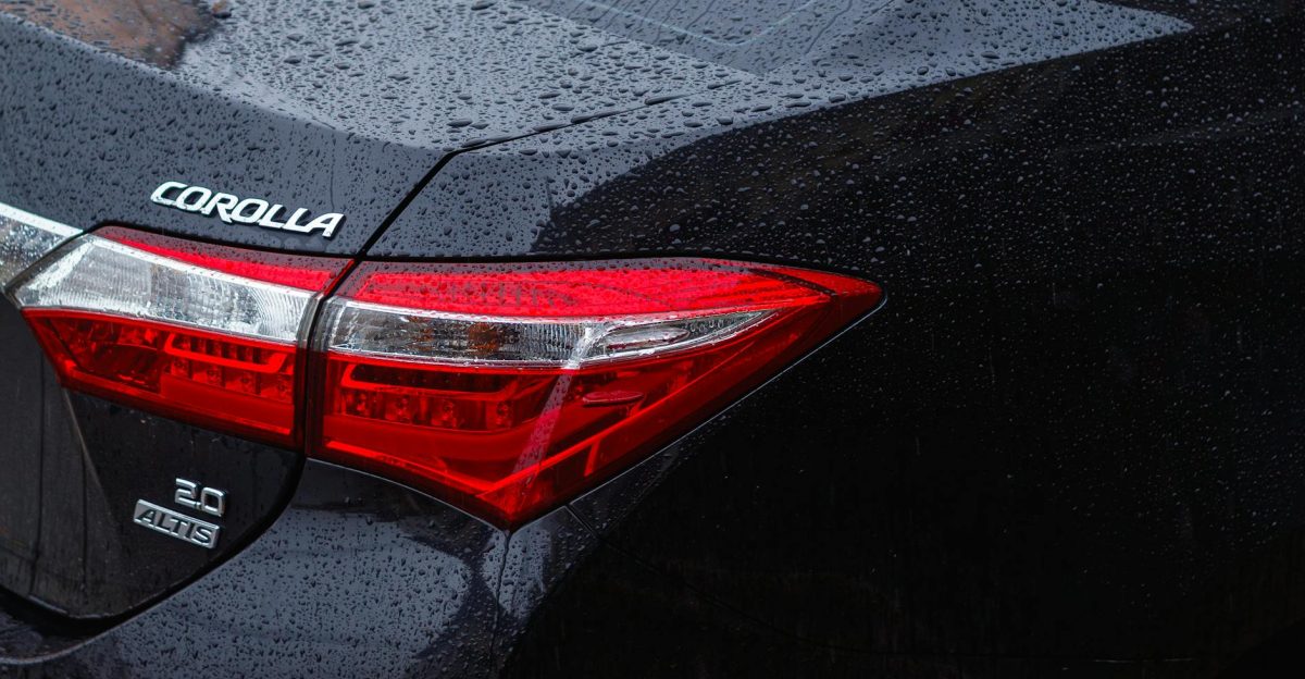 Detailed rear view of a Toyota Corolla in the rain showcasing raindrops on the car surface