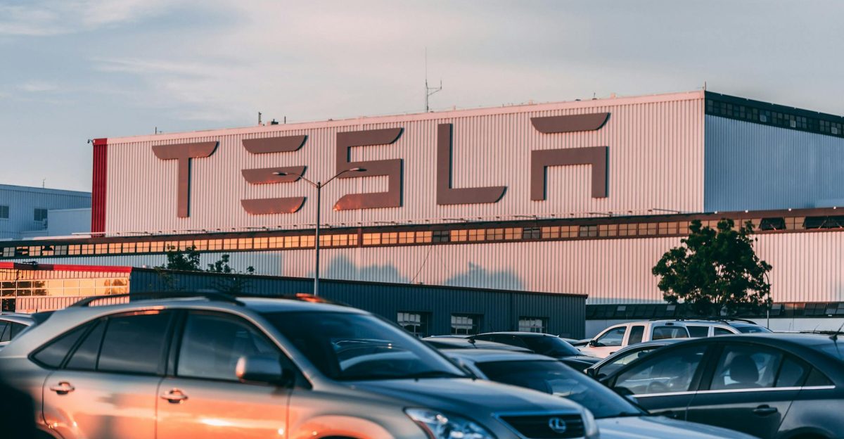 Tesla factory with parked cars during sunset showcasing modern automotive industry vibes