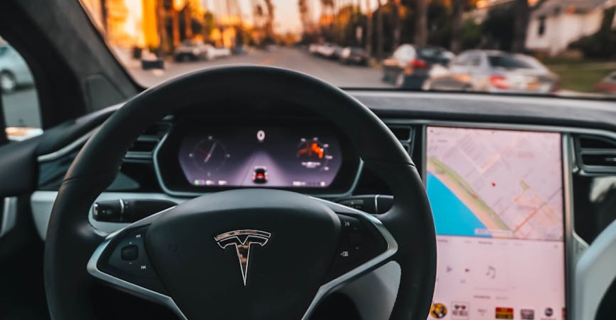 Interior view of a Tesla Model X steering through palm-lined streets of Santa Monica at twilight