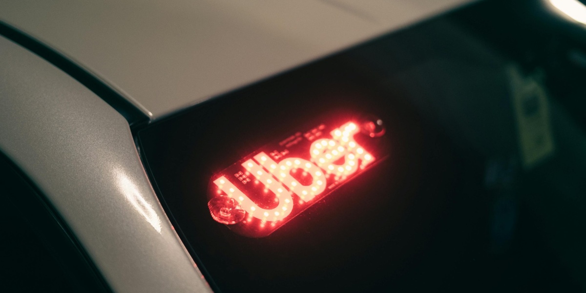 Close-up of a ride-sharing car with a bright red illuminated sign for night-time travel.