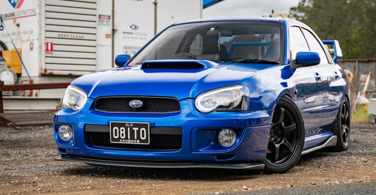 A blue Subaru WRX STI parked in an industrial area emphasizing automotive culture and rugged style