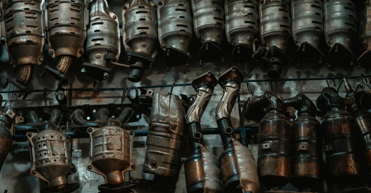 Rows of used catalytic converters in an automotive workshop setting