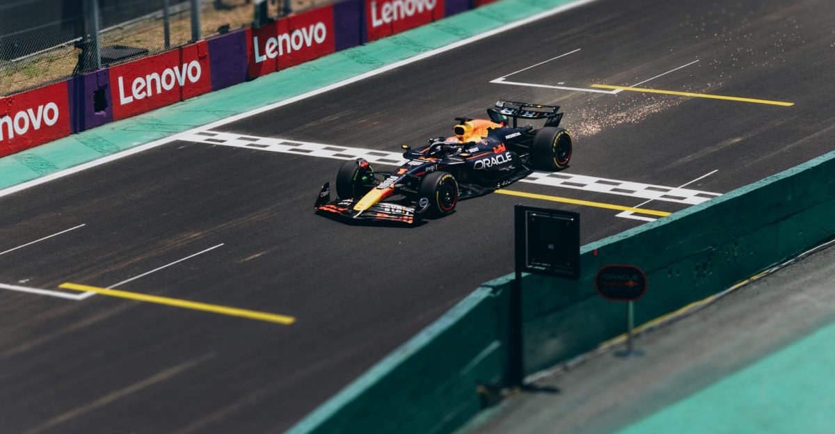 Formula 1 car speeding across the finish line on a racetrack emitting sparks