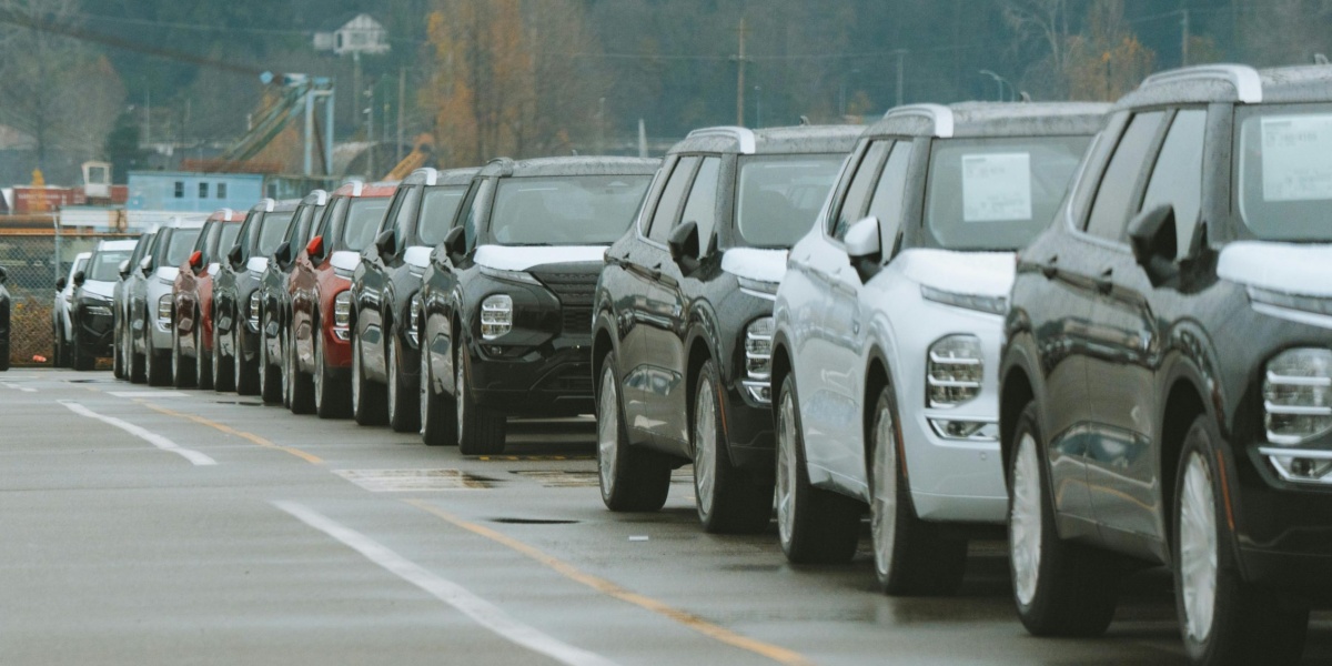 A line of new SUVs parked in an outdoor dealership lot, ready for sale.