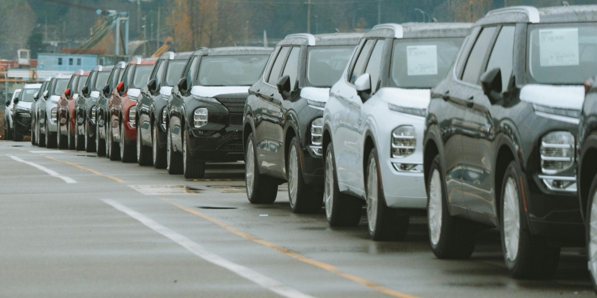 A line of new SUVs parked in an outdoor dealership lot, ready for sale.