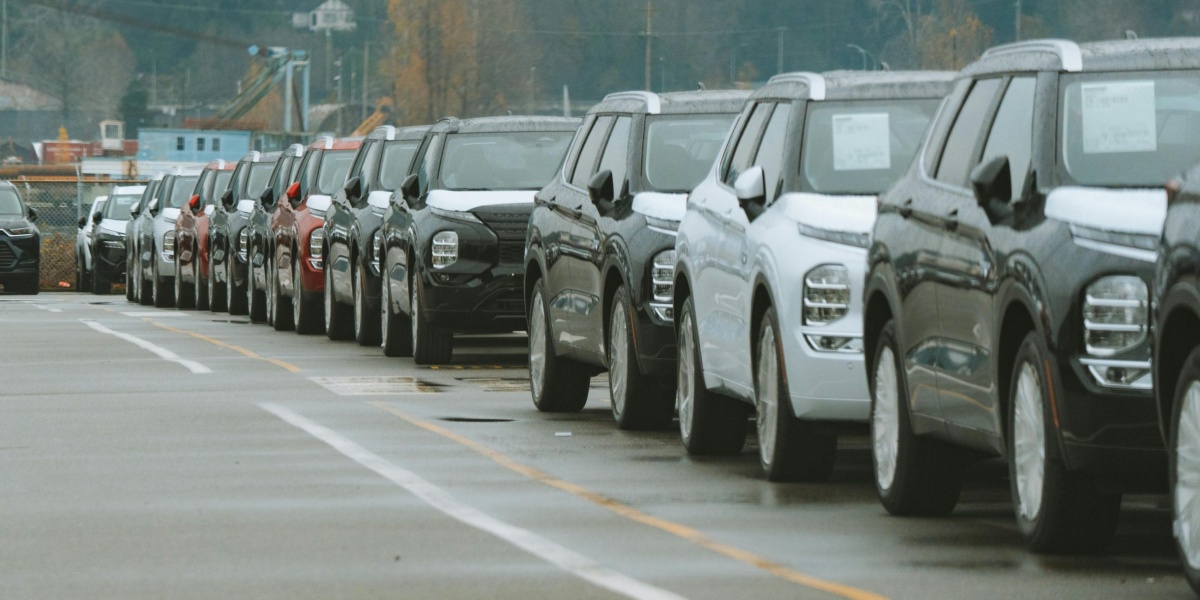 A line of new SUVs parked in an outdoor dealership lot, ready for sale.