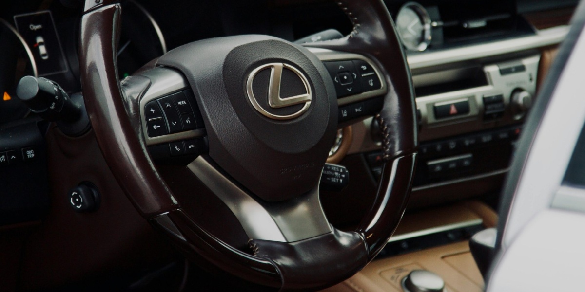 Close-up of a Lexus car interior highlighting the steering wheel in a luxury setting.