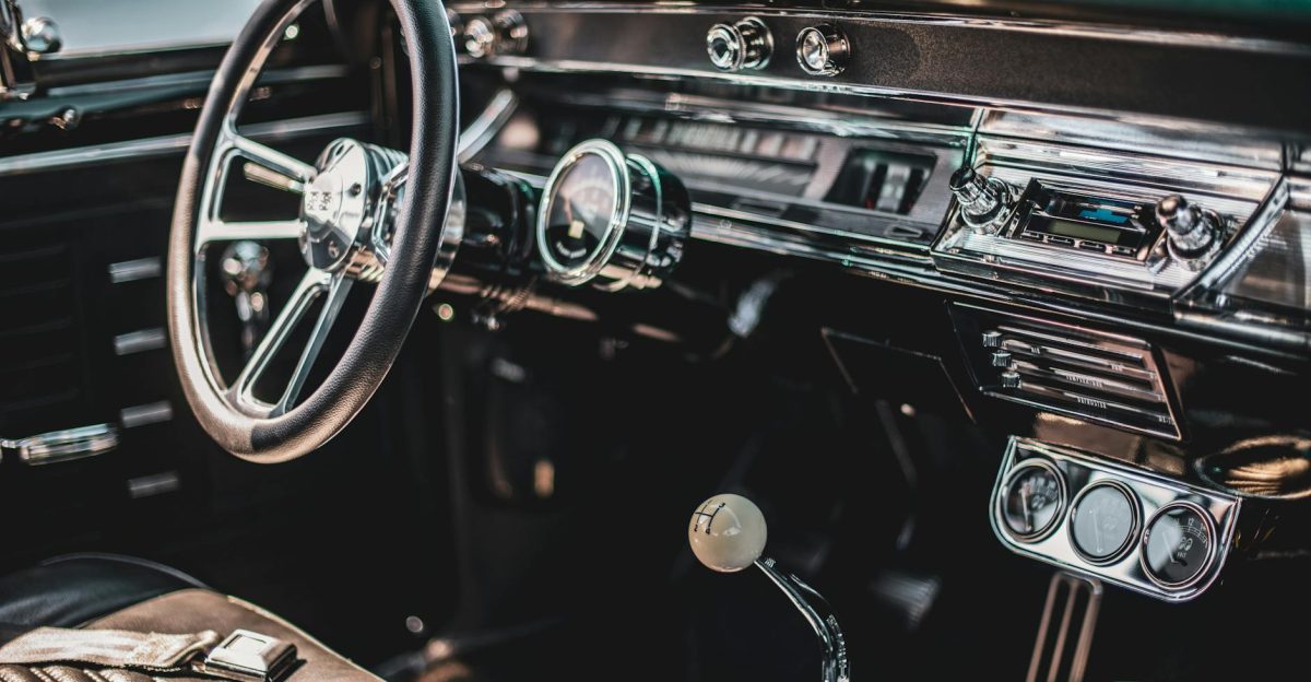 A detailed view of a classic car s interior featuring a vintage dashboard and steering wheel