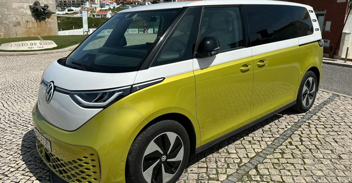 Volkswagen ID Buzz parked on cobblestone street in scenic Portuguese town under clear skies