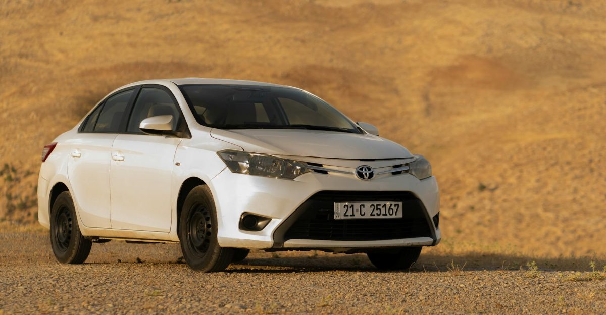 A modern white Toyota car parked in a vast desert setting perfect for automotive imagery