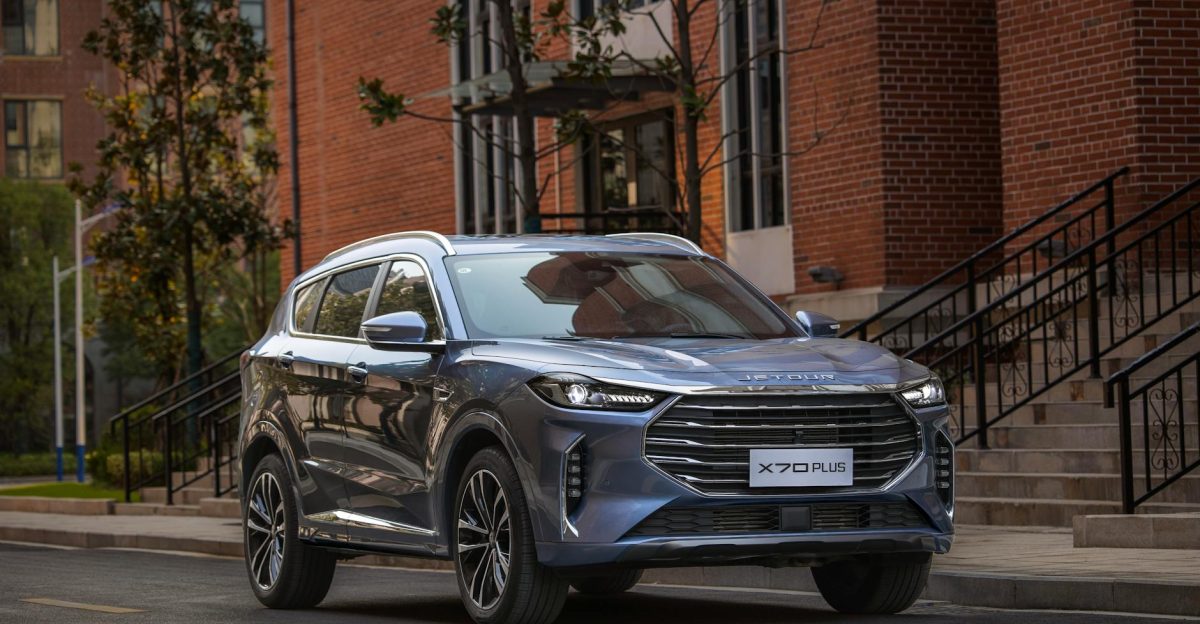 A sleek blue SUV parked on a city street showcasing its modern design against a brick building