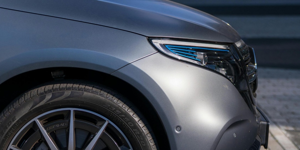 Silver electric vehicle at a charging station in the city, showcasing modern transportation.