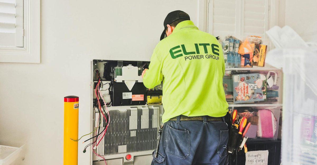 A technician from Elite Power Group installing a home battery system indoors in New South Wales Australia