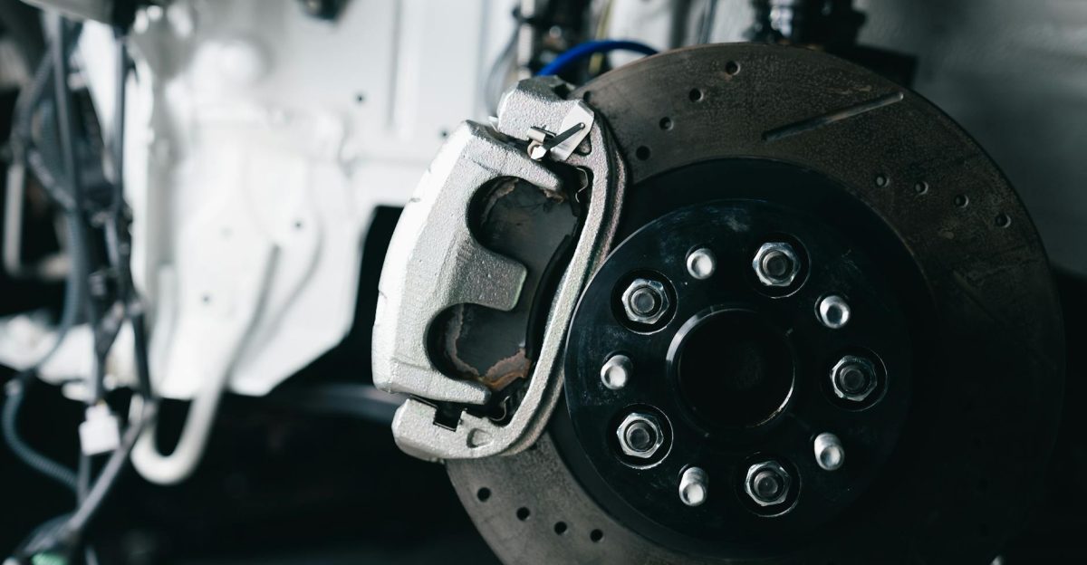Detailed view of a car s brake caliper and disc in a workshop setting