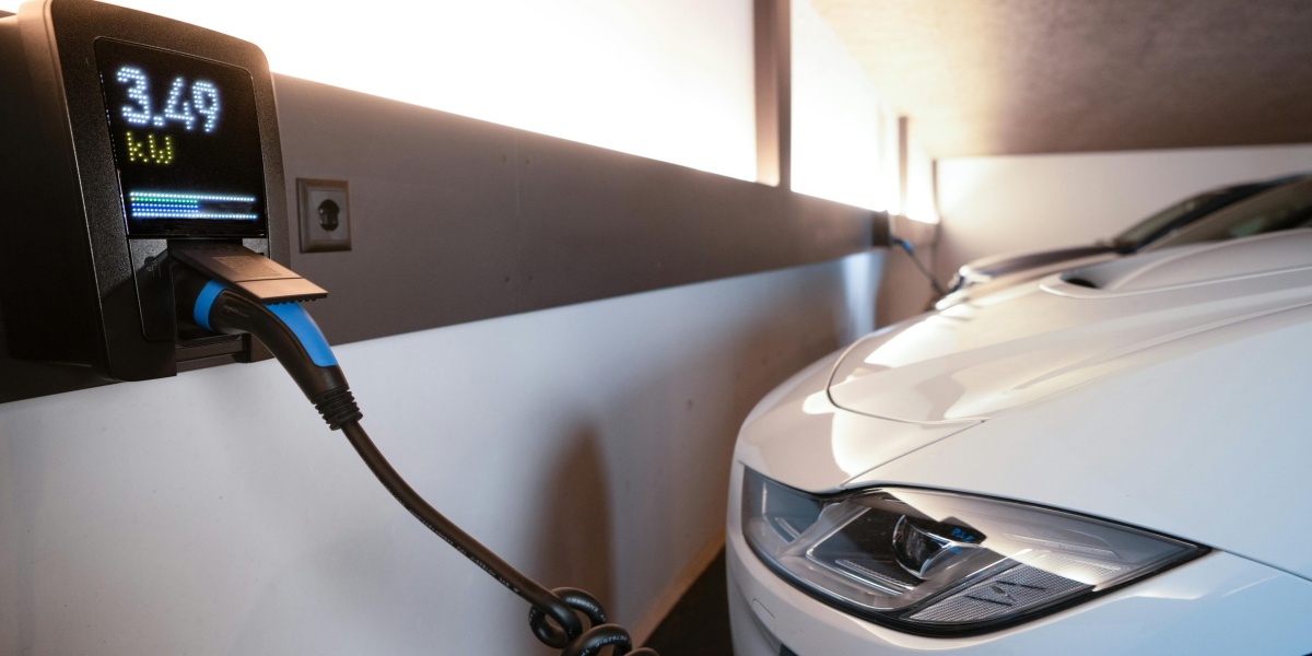 White electric car charging at indoor station, emphasizing sustainability and efficiency.