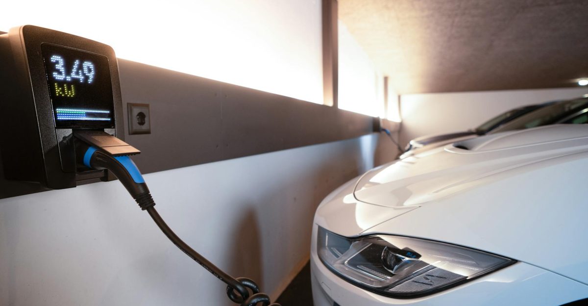 White electric car charging at indoor station emphasizing sustainability and efficiency