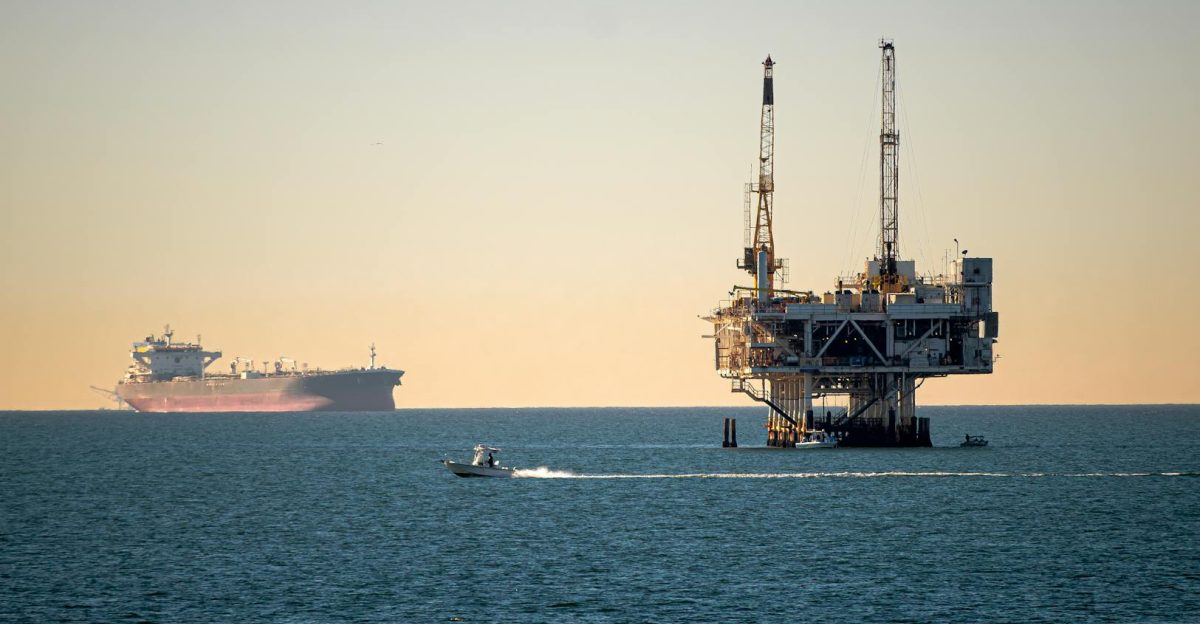 Offshore oil platform with container ship in tranquil sea during daytime
