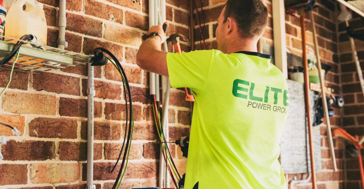 Electrician performing solar battery installation for sustainable energy storage in a home setting