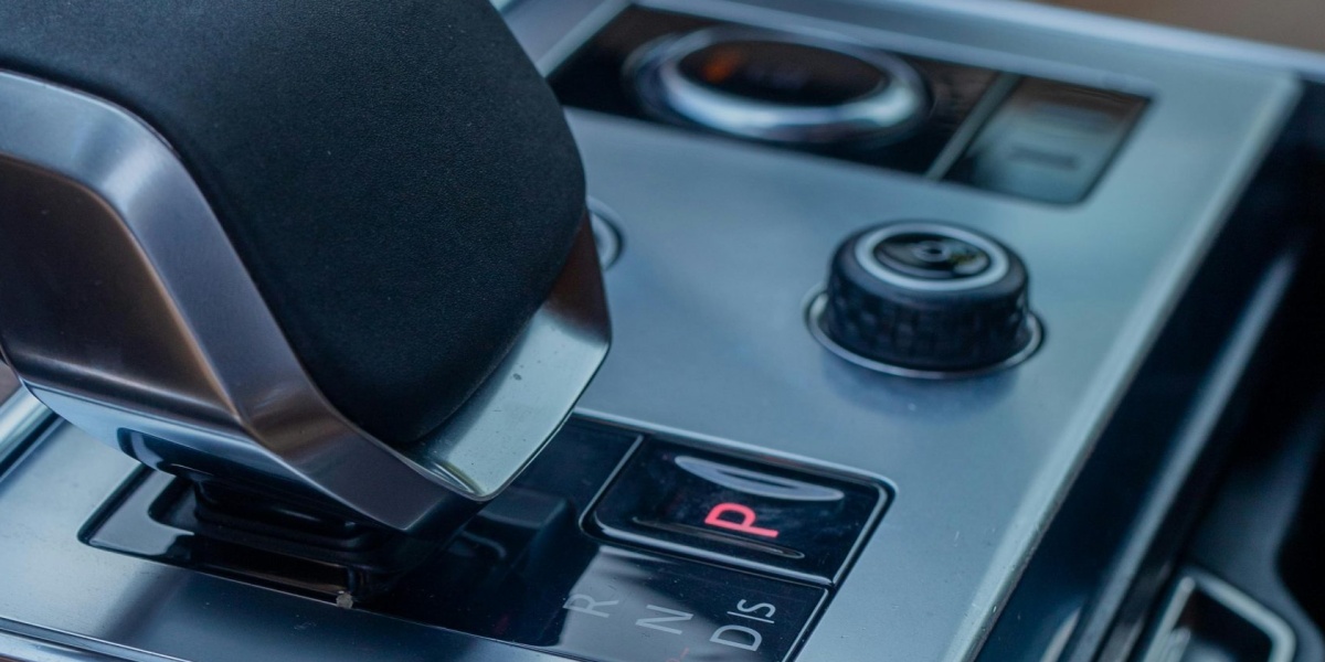 Close-up view of a luxury SUV gear selector, showcasing sleek design in a modern car interior.