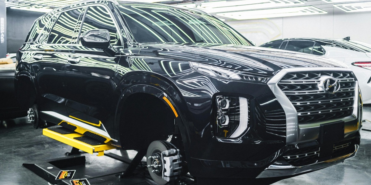 A Hyundai Palisade luxury SUV displayed in a sleek, modern garage under stylish lighting.