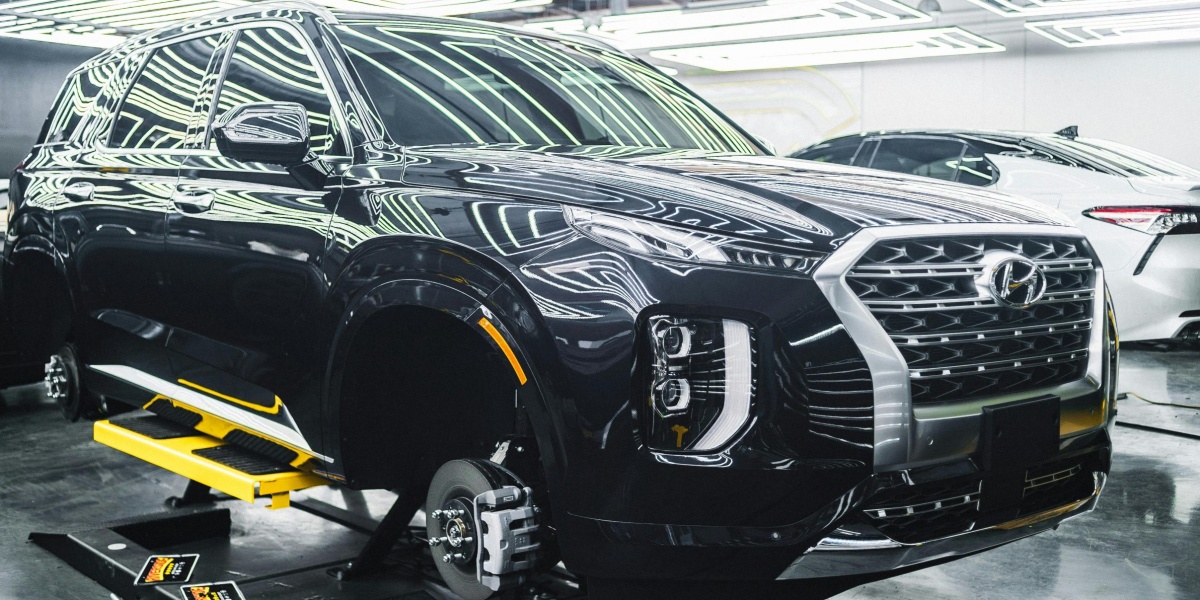 A Hyundai Palisade luxury SUV displayed in a sleek, modern garage under stylish lighting.