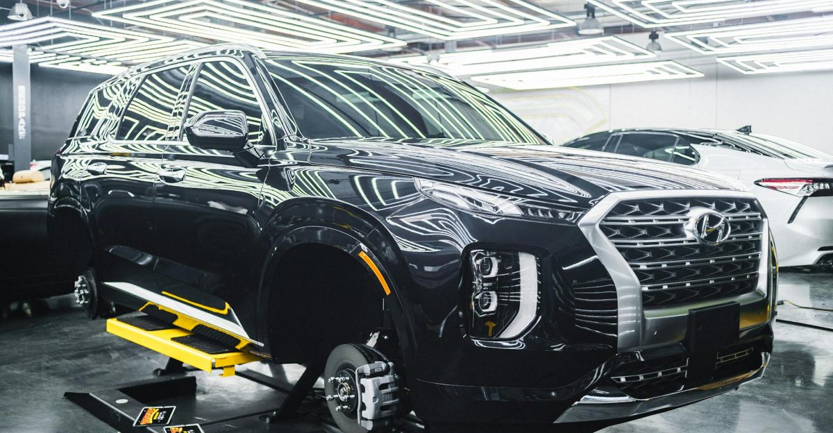 A Hyundai Palisade luxury SUV displayed in a sleek modern garage under stylish lighting