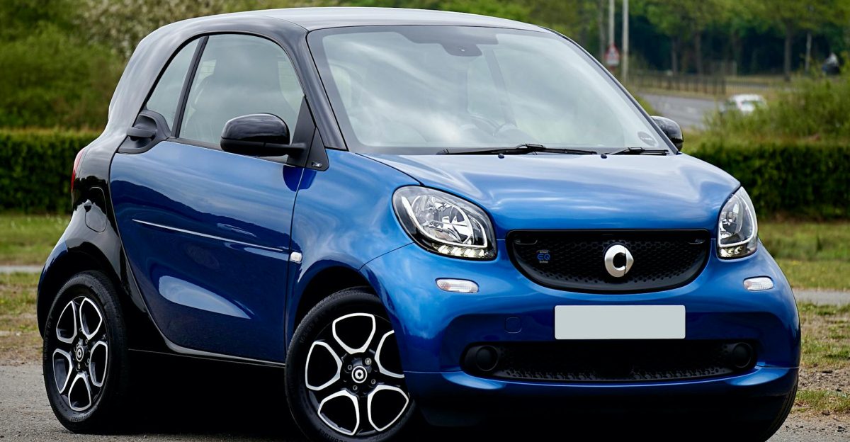 A shiny blue electric car parked outdoors on a pleasant day in the UK