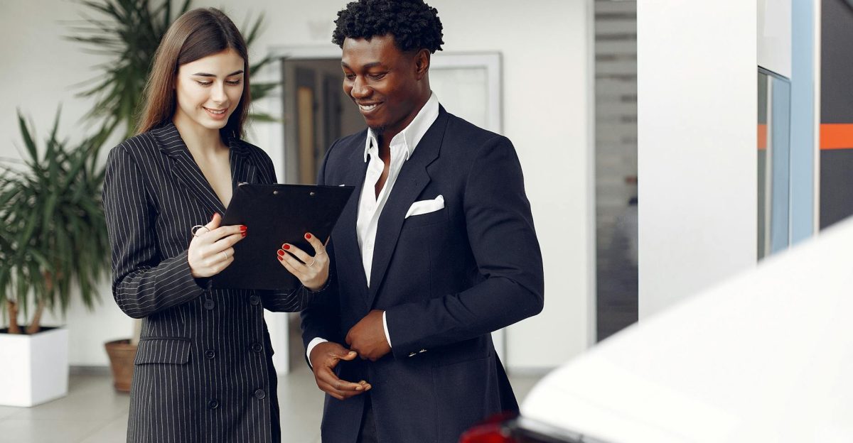 Two professionals discussing options inside a car dealership