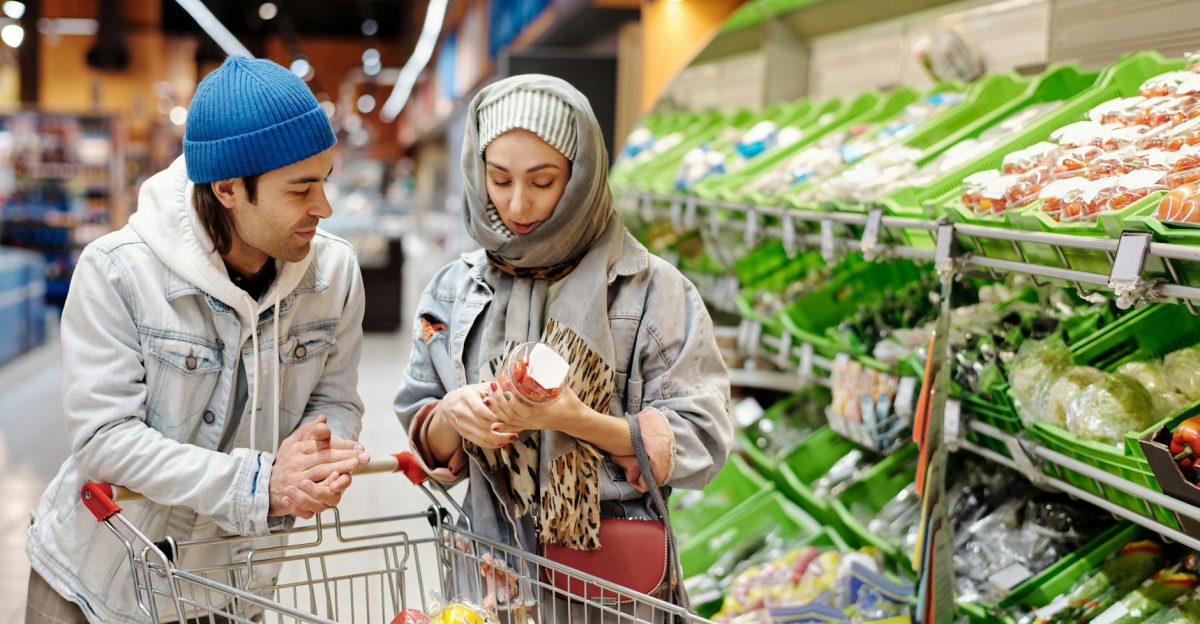 Middle Eastern couple shopping together for fresh vegetables in a supermarket produce aisle