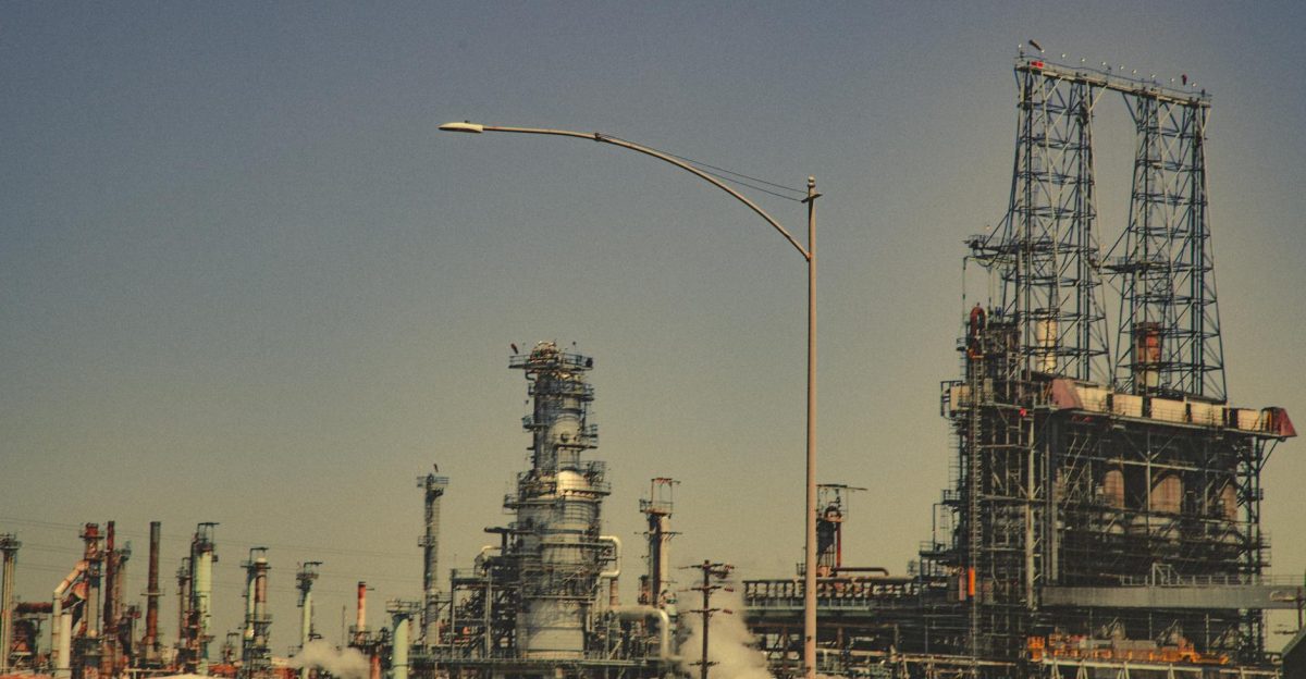 A large industrial refinery with pipes and towers under a clear blue sky during the day