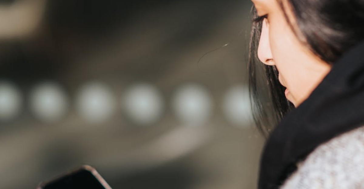 Side view of a woman texting on her smartphone outdoors