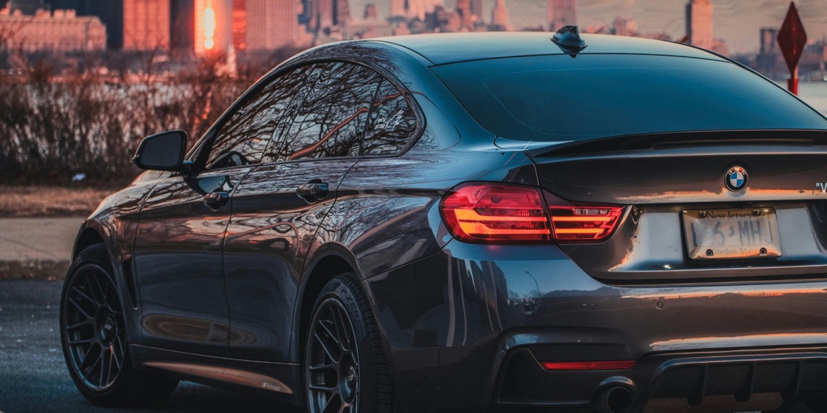 A sleek BMW coupe parked with a stunning city skyline backdrop at sunset, showcasing urban luxury lifestyle.