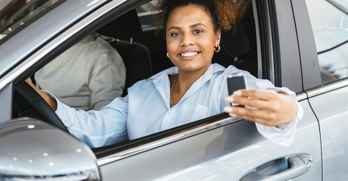 Cheerful woman with car key sitting inside a modern vehicle showcasing joy and ownership