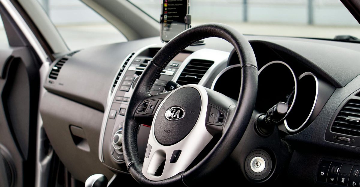 Close-up of a modern car interior featuring a dashboard steering wheel and smartphone mount