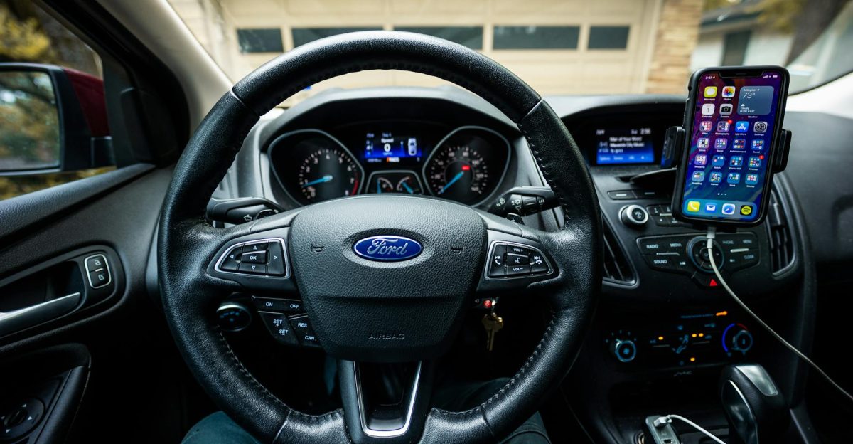 Interior view of a Ford car featuring a steering wheel dashboard and mobile device mount