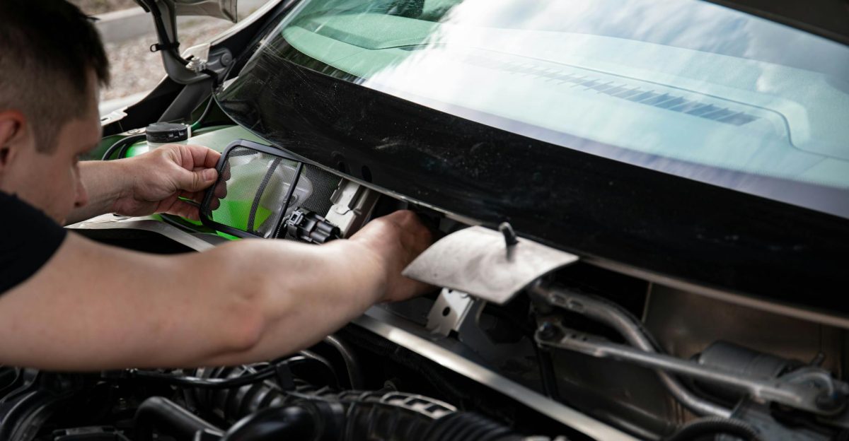 A mechanic working on car maintenance Close-up of hands fixing vehicle engine
