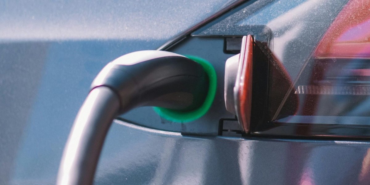 Close-up of an electric car plugged into a charging station, showcasing modern technology.