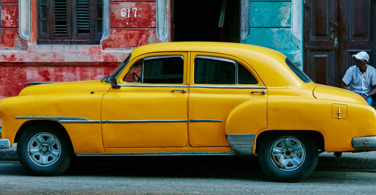 yellow sedan parked near red concrete building